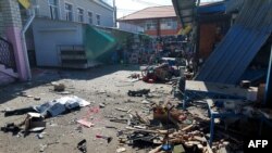 Тіло місцевого жителя лежить на ринку в центрі українського міста Херсон після російського обстрілу, 18 квітня 2023 року