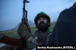 Rustam atly 35 ýaşyndaky ukrain soldaty Donetsk oblastynyň Nowohrodiwka şäheriniň eteginde, maşynyň üstünde oturyp, ýokardan duşman dronlaryna gözegçilik edýär, 31-nji awgust.