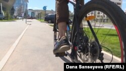 Велосипед теуіп бара жатқан адам. Астана. Тамыз, 2017 жыл.