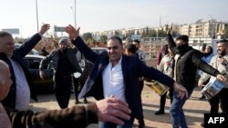 Сирийцы танцуют перед тюрьмой в Алеппо, из которой повстанцы освобождают заключённых