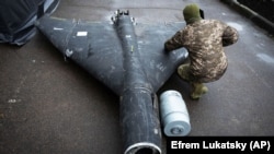 Український військовий оглядає збитий раніше безпілотник Shahed із термобаричним зарядом, що був запущений Росією, 14 листопада 2024 року